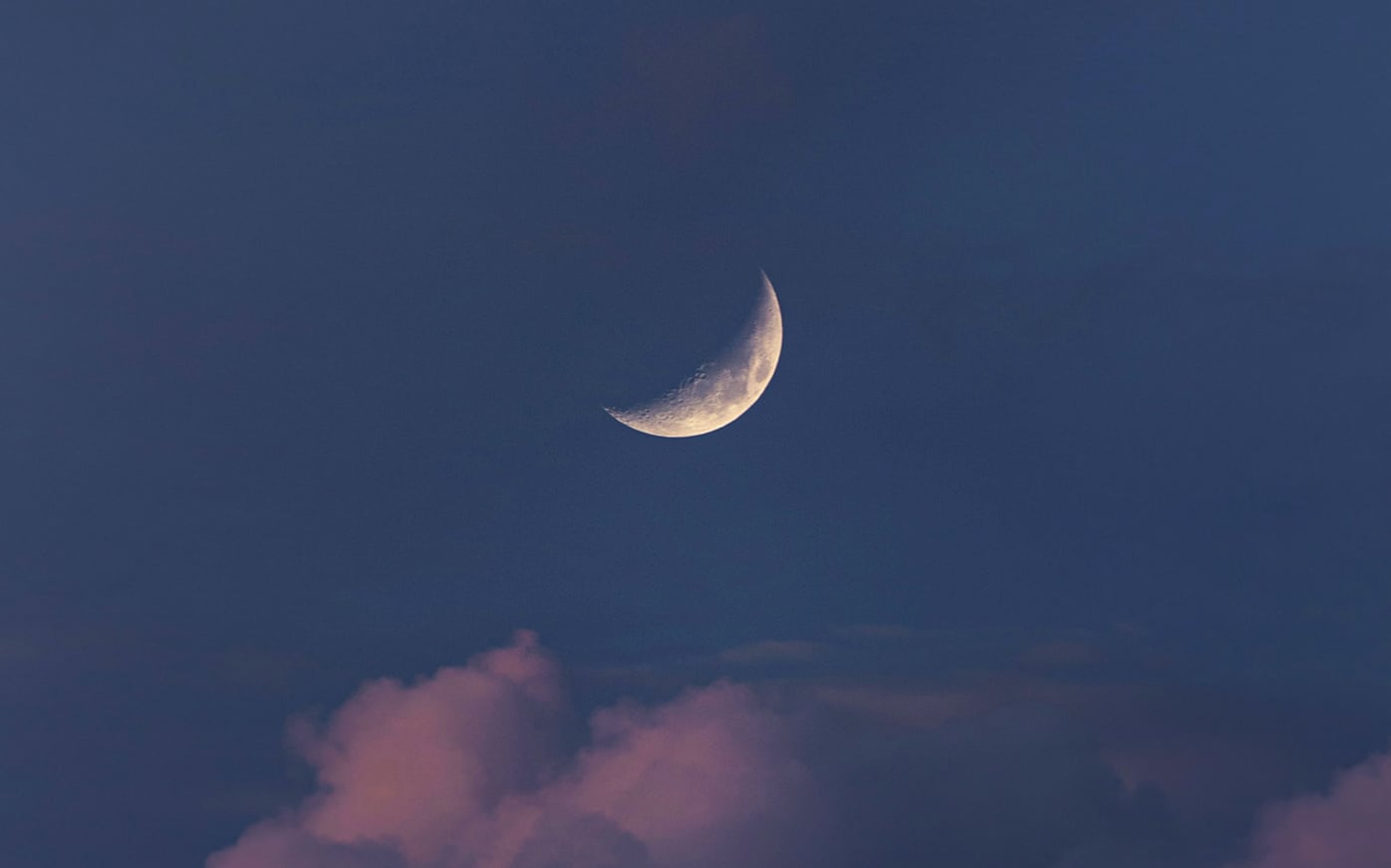 crescent moon in the blue sky with purple clouds